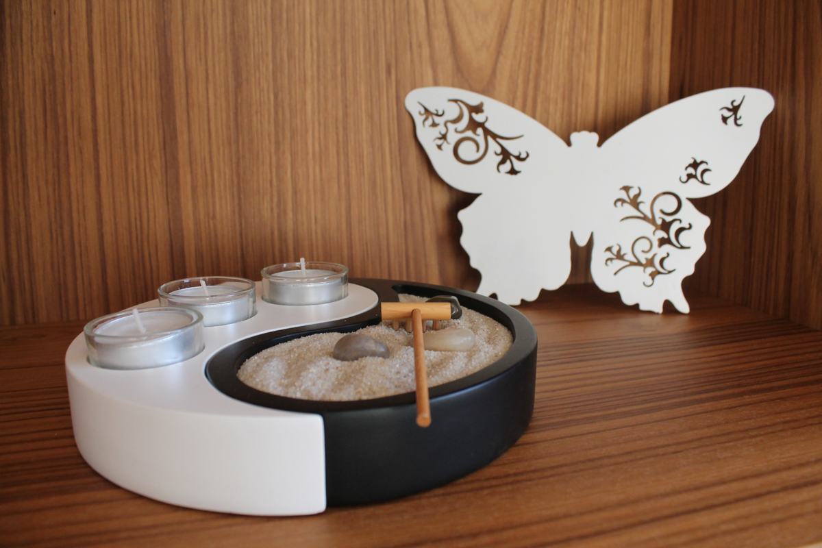 Zen-Garten mit Teelichtern und weissem Schmetterling